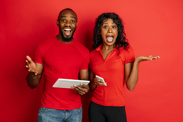 Image showing Young emotional african-american man and woman on red background