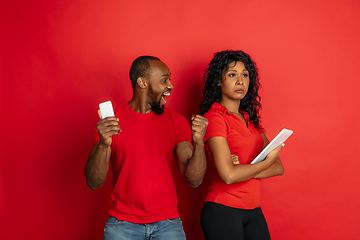 Image showing Young emotional african-american man and woman on red background