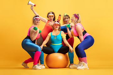 Image showing Young caucasian plus size female models training on yellow background