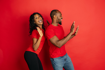 Image showing Young emotional african-american man and woman on red background