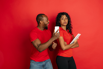 Image showing Young emotional african-american man and woman on red background