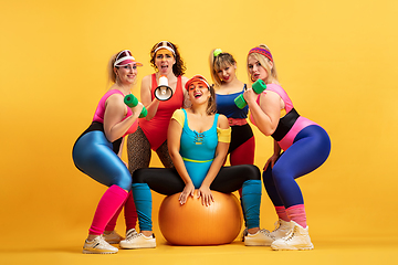 Image showing Young caucasian plus size female models training on yellow background