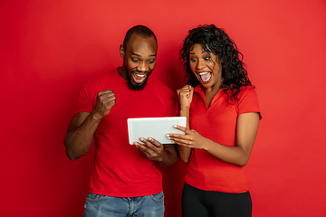 Image showing Young emotional african-american man and woman on red background