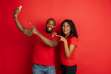 Image showing Young emotional african-american man and woman on red background