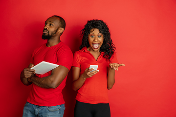 Image showing Young emotional african-american man and woman on red background