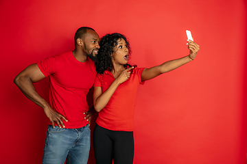 Image showing Young emotional african-american man and woman on red background