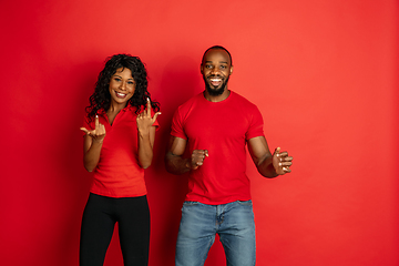 Image showing Young emotional african-american man and woman on red background