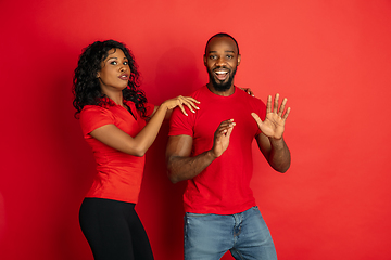 Image showing Young emotional african-american man and woman on red background