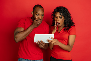 Image showing Young emotional african-american man and woman on red background