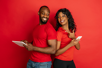 Image showing Young emotional african-american man and woman on red background