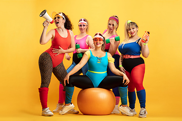 Image showing Young caucasian plus size female models training on yellow background