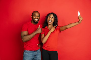 Image showing Young emotional african-american man and woman on red background