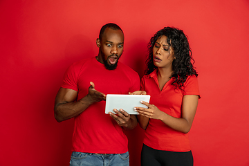 Image showing Young emotional african-american man and woman on red background