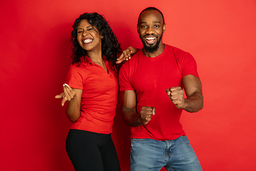 Image showing Young emotional african-american man and woman on red background