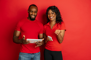 Image showing Young emotional african-american man and woman on red background