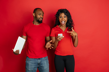 Image showing Young emotional african-american man and woman on red background