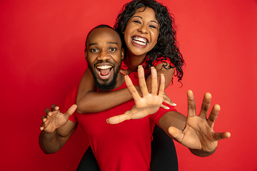 Image showing Young emotional african-american man and woman on red background