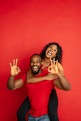 Image showing Young emotional african-american man and woman on red background