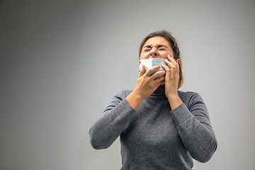 Image showing Caucasian woman wearing the respiratory protection mask against air pollution and dusk on grey studio background