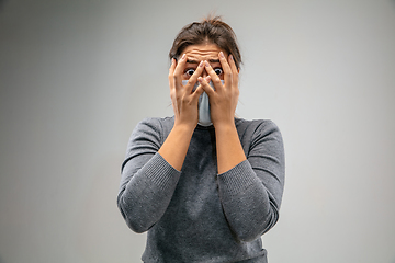 Image showing Caucasian woman wearing the respiratory protection mask against air pollution and dusk on grey studio background