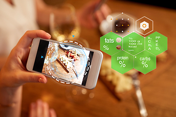 Image showing hands with food on smartphone screen at restaurant