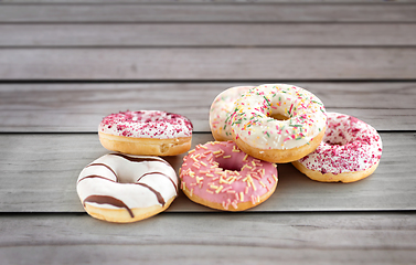 Image showing close up of glazed donuts on wooden boards