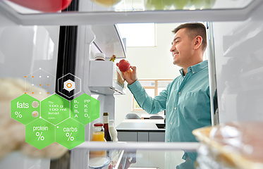 Image showing man taking apple from fridge at home kitchen