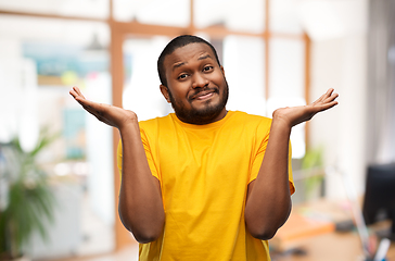 Image showing african american man in yellow t-shirt shrugging