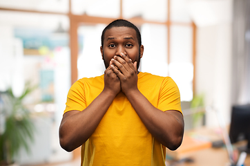 Image showing scared african american man covering his mouth