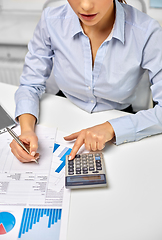 Image showing businesswoman with papers and calculator at office