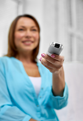 Image showing close up of woman with tv remote control at home