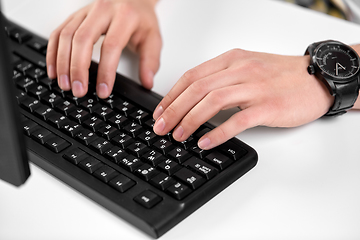 Image showing male hands typing on computer keyboard on table