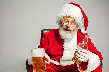 Image showing Santa Claus drinking beer sitting on armchair, congratulating of New Year 2020