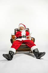 Image showing Santa Claus drinking beer sitting on armchair, congratulating of New Year 2020