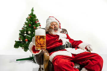 Image showing Santa Claus drinking beer near Christmas tree, congratulating of