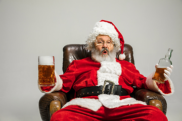 Image showing Santa Claus drinking beer sitting on armchair, congratulating of New Year 2020