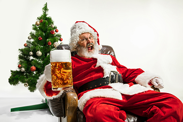 Image showing Santa Claus drinking beer near Christmas tree, congratulating of