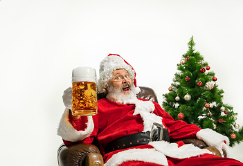 Image showing Santa Claus drinking beer near Christmas tree, congratulating of