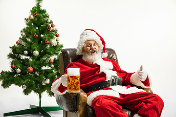 Image showing Santa Claus drinking beer near Christmas tree, congratulating of