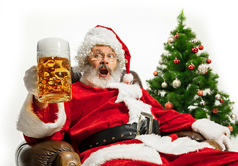 Image showing Santa Claus drinking beer near Christmas tree, congratulating of