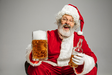 Image showing Santa Claus drinking beer sitting on armchair, congratulating of New Year 2020