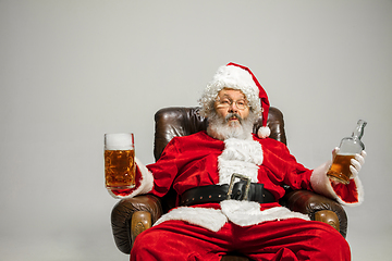 Image showing Santa Claus drinking beer sitting on armchair, congratulating of New Year 2020