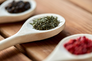 Image showing spoons with different spices on wooden table