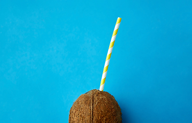 Image showing coconut drink with paper straw on blue background
