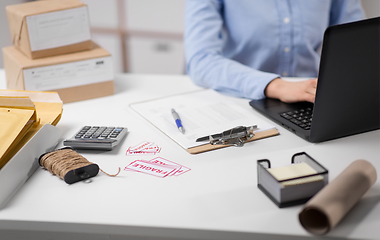 Image showing woman with laptop and clipboard at post office