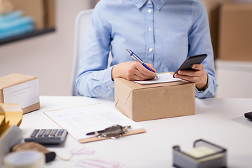 Image showing close up of woman filling postal form at office