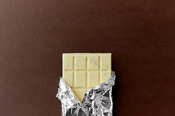 Image showing white chocolate bar in foil wrapper on brown