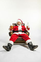 Image showing Santa Claus drinking beer sitting on armchair, congratulating of New Year 2020