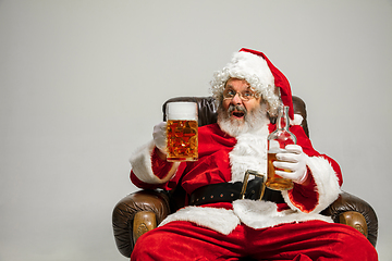 Image showing Santa Claus drinking beer sitting on armchair, congratulating of New Year 2020