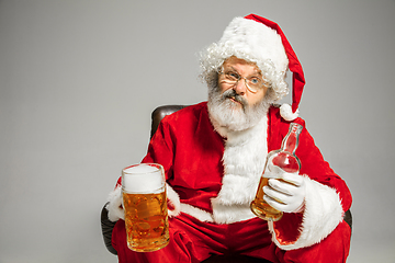 Image showing Santa Claus drinking beer sitting on armchair, congratulating of New Year 2020